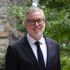 Temple University President John Fry wearing a suit and smiling